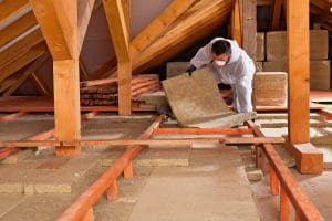 An insulation contractor installs insulation in an attic.